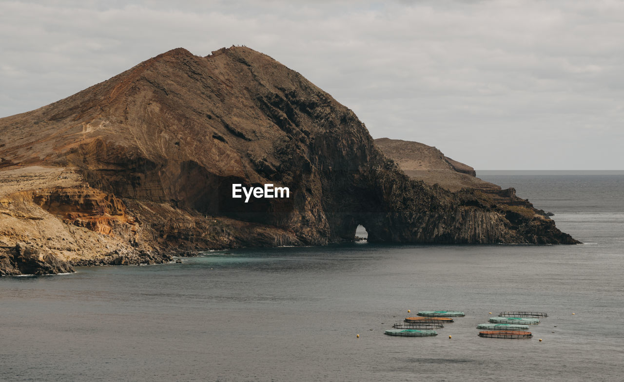 Scenic view of sea and mountains against sky