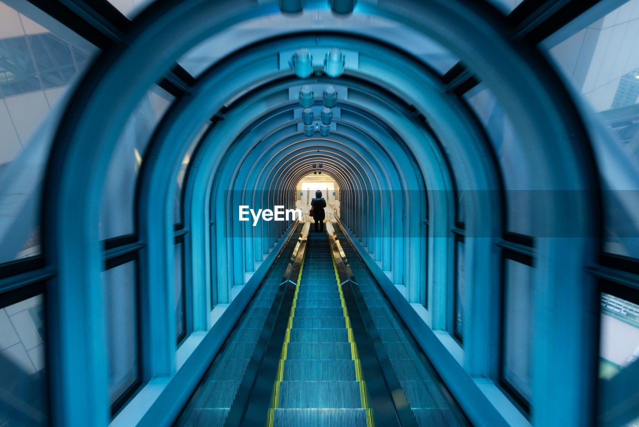 Rear view of man walking in tunnel