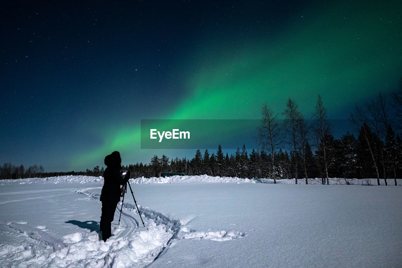 Women photographing the northern lights in lapland