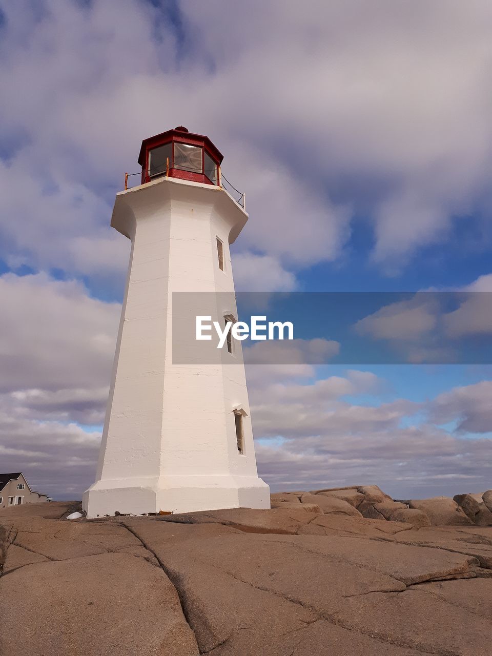 Lighthouse against sky with clouds