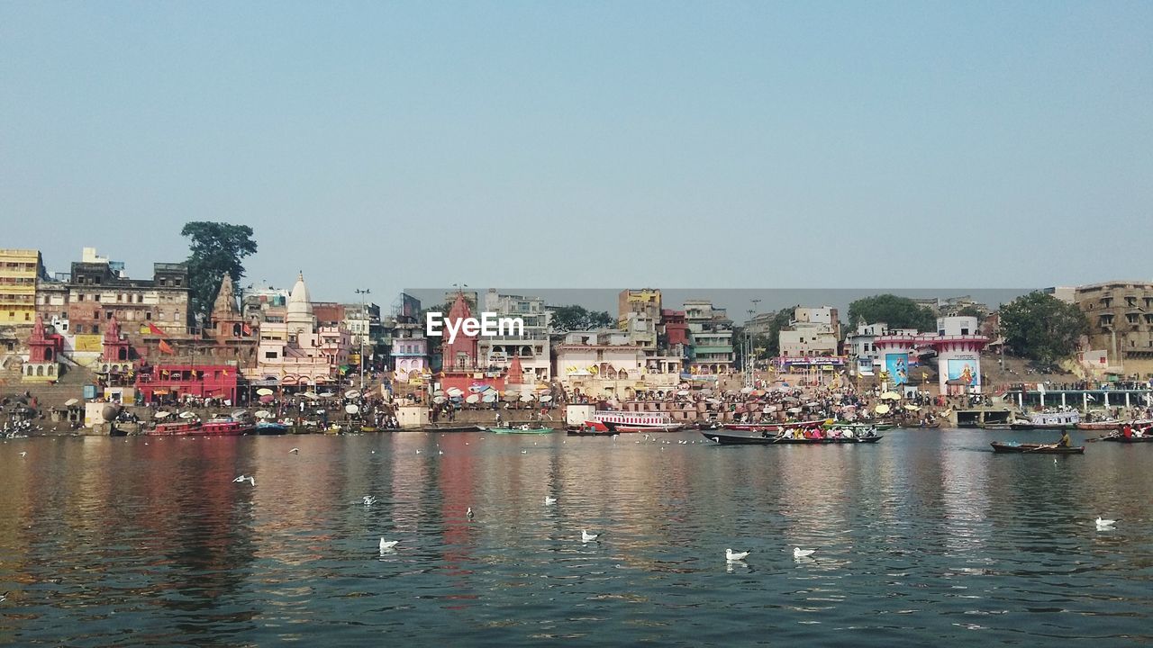 VIEW OF TOWNSCAPE BY RIVER AGAINST SKY