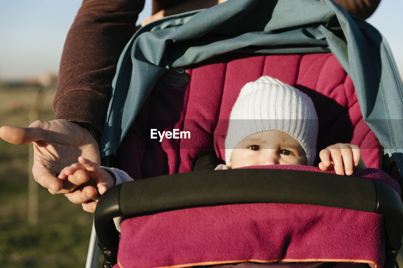 Midsection of father pushing baby in stroller