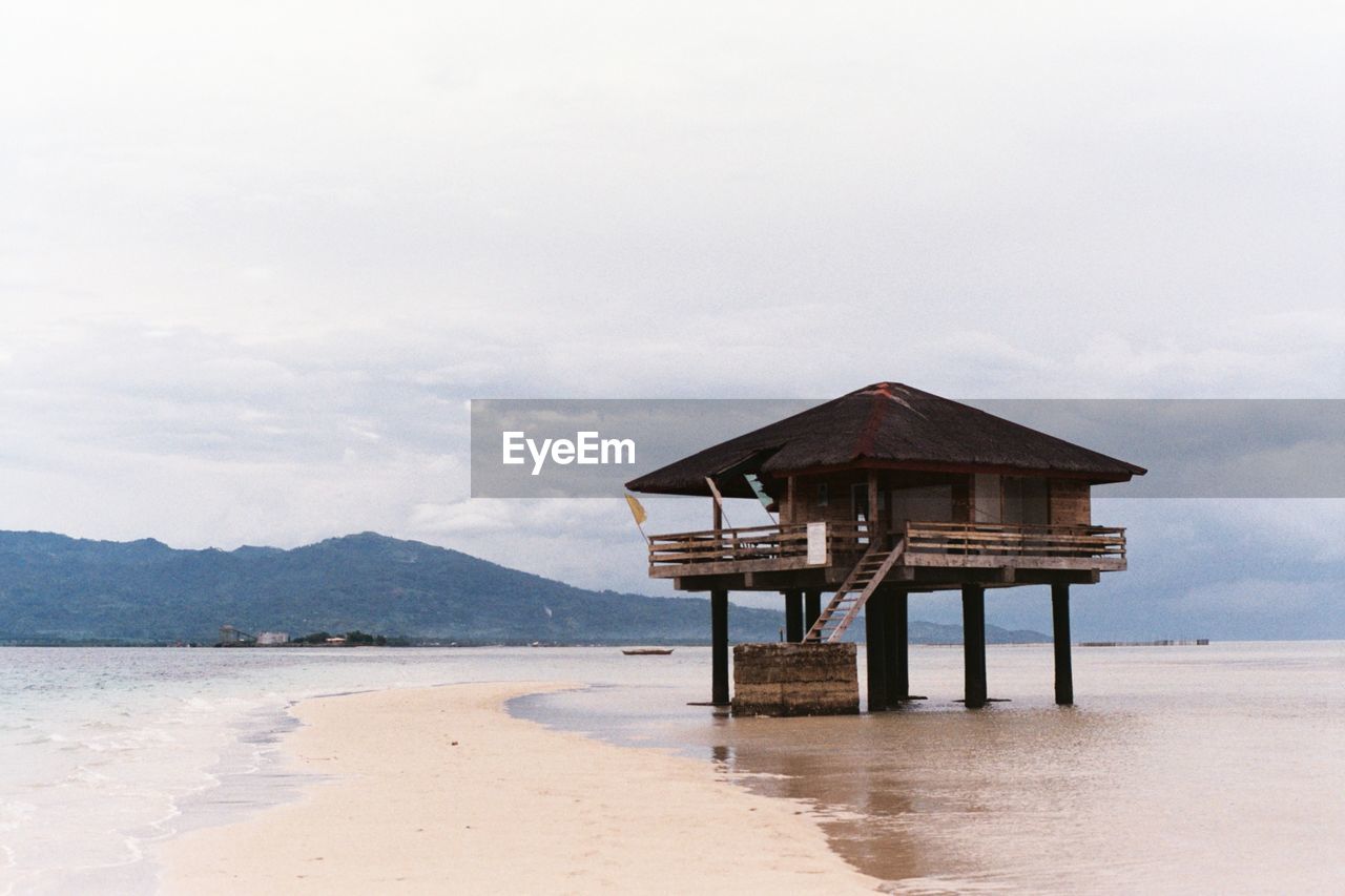 Lifeguard hut on beach against sky