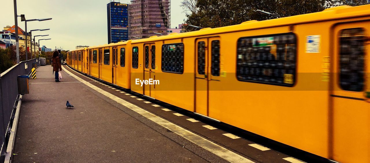 TRAIN ON RAILROAD STATION PLATFORM IN CITY