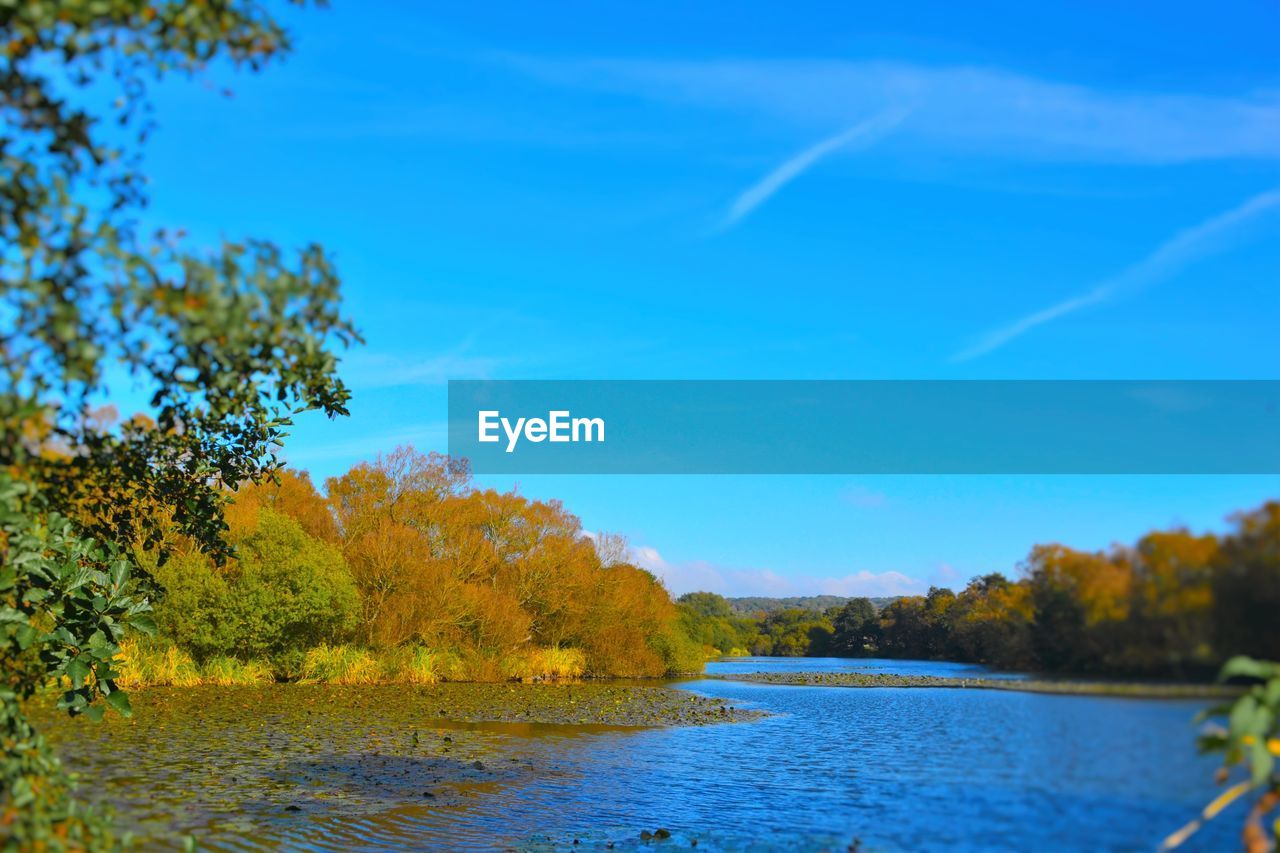 SCENIC VIEW OF CALM LAKE AGAINST SKY