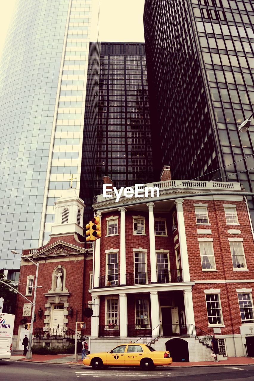Low angle view of church against modern buildings