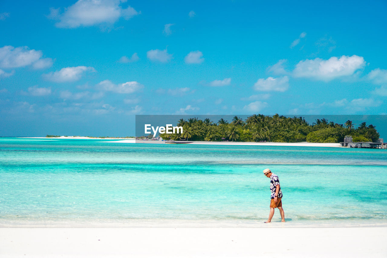 Man standing on beach against sky