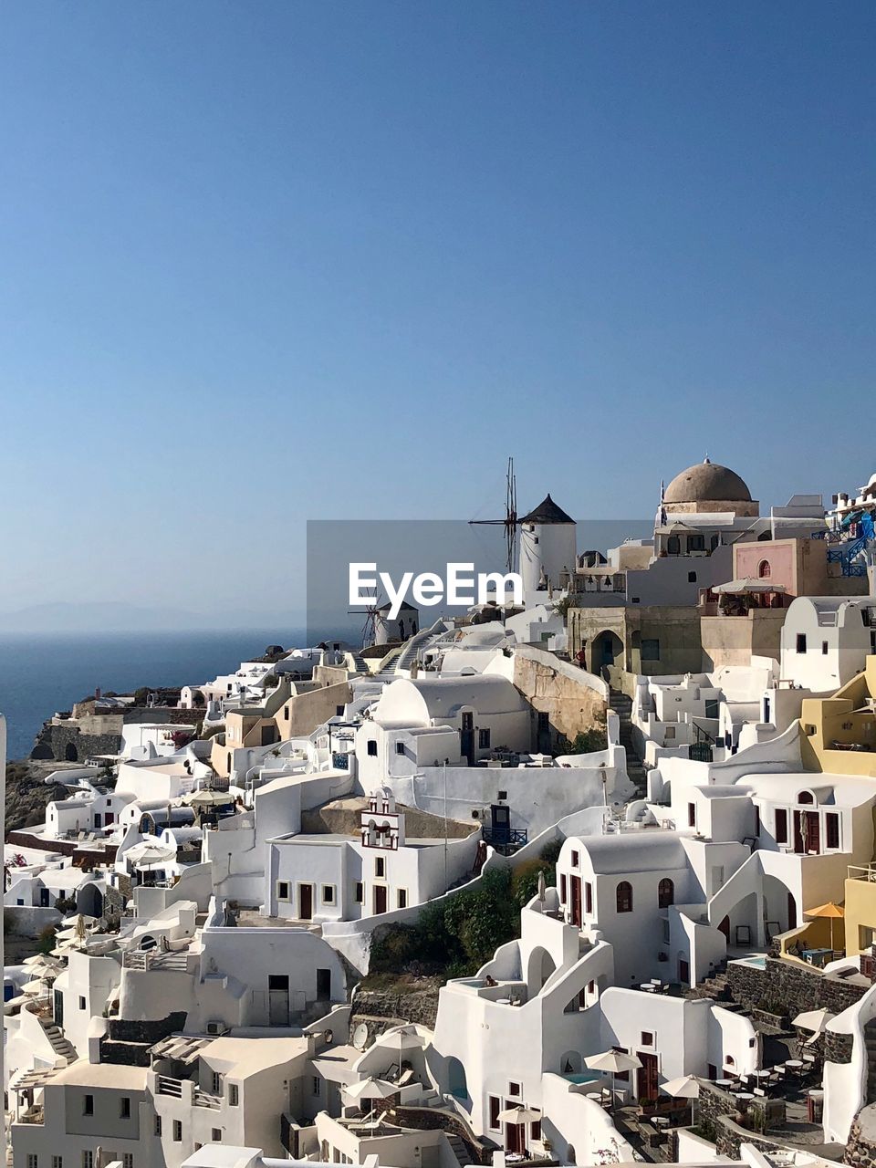 High angle view of townscape by sea against clear sky