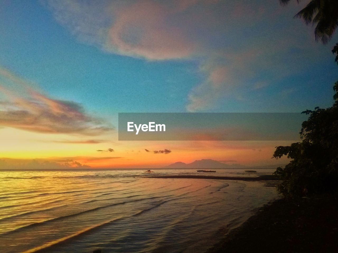 SCENIC VIEW OF BEACH AGAINST SKY AT SUNSET