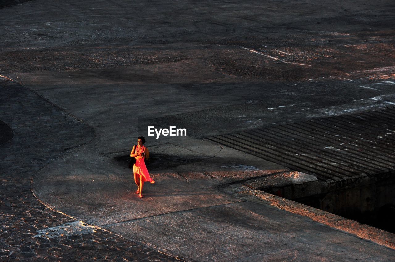 Women in red, lone on a pier