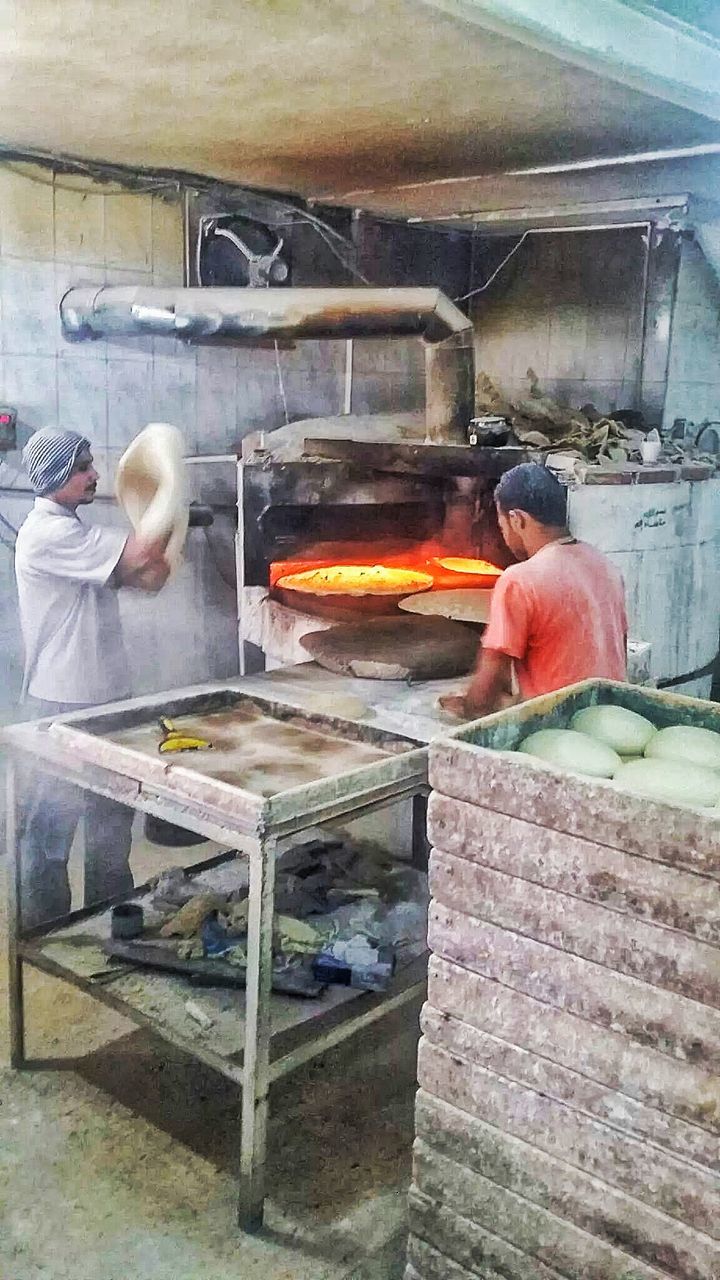 VIEW OF MAN WORKING IN KITCHEN