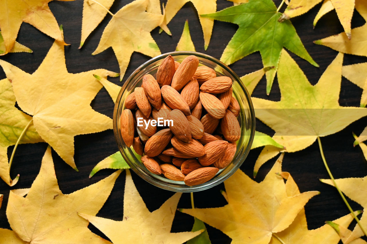 High angle view of almond nuts and leaves on table