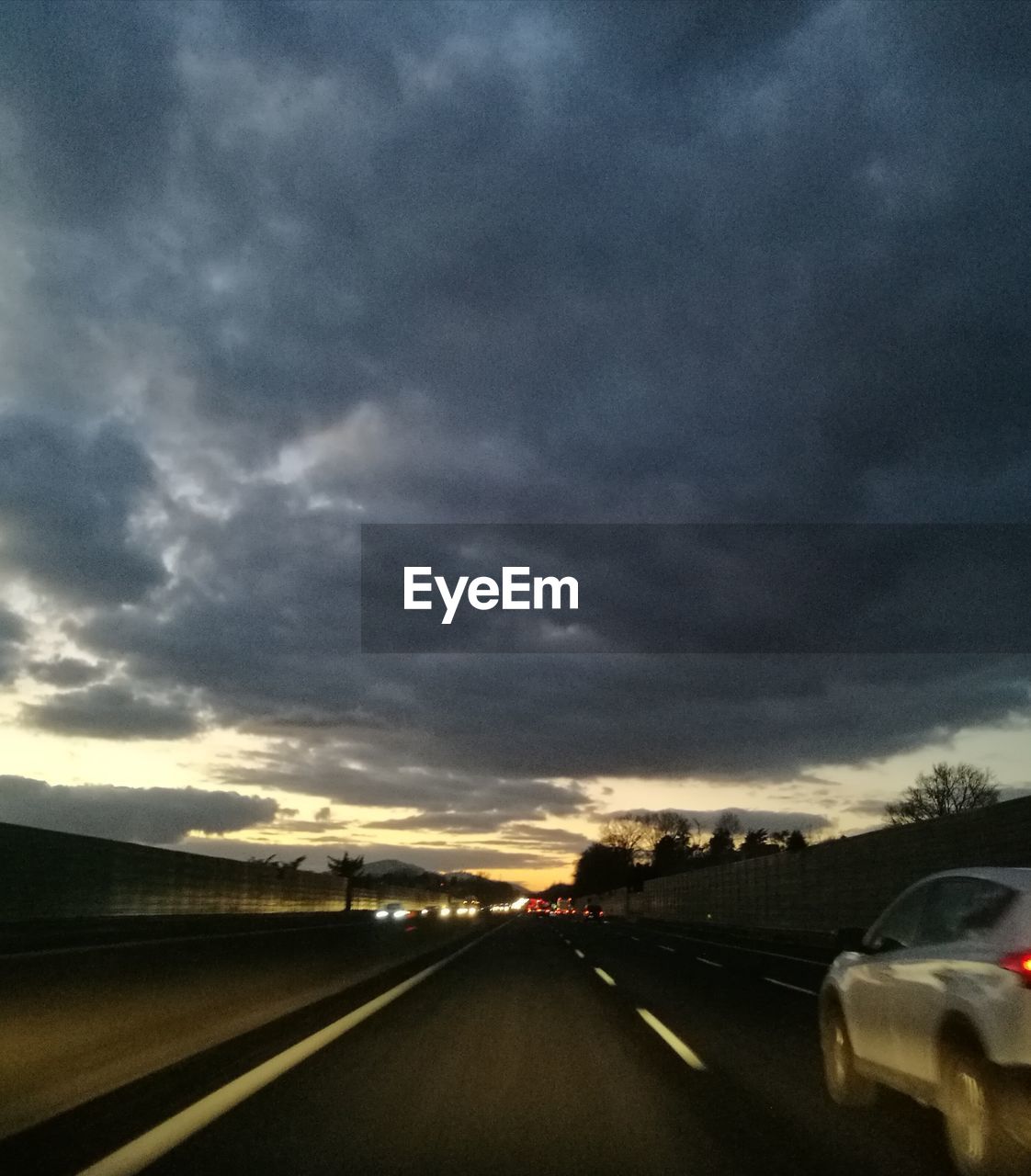 ROAD AGAINST CLOUDY SKY AT SUNSET