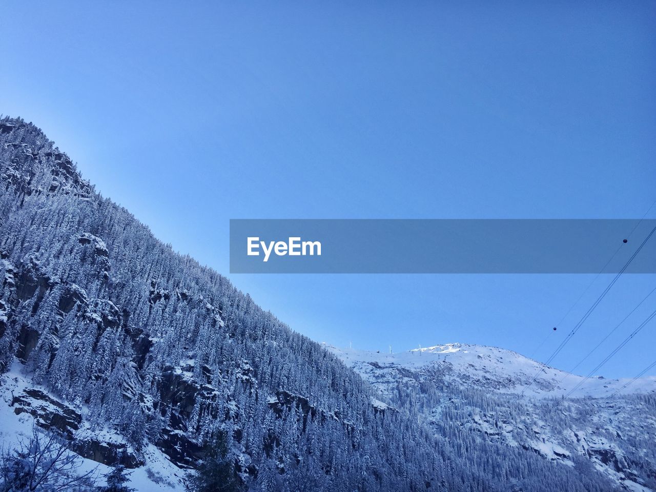 Scenic view of snowcapped mountains against blue sky