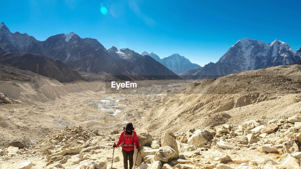 Woman walking on mountain during sunny day