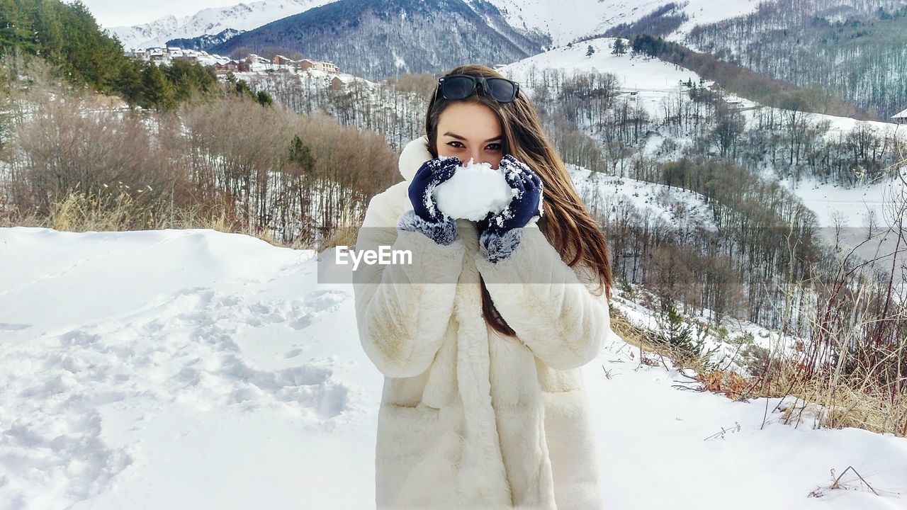 Portrait of young woman standing in snow