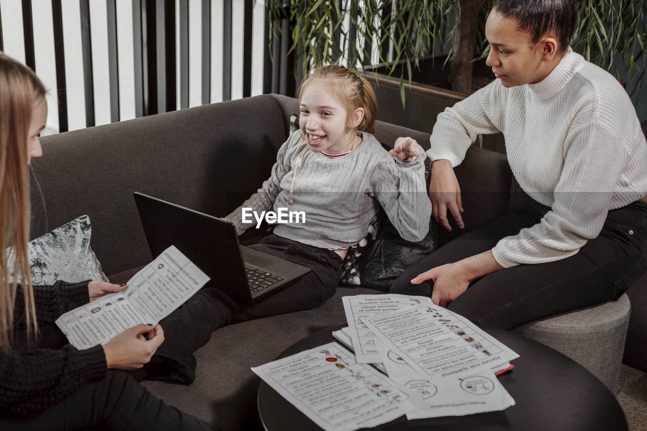 Women teaching girl at home