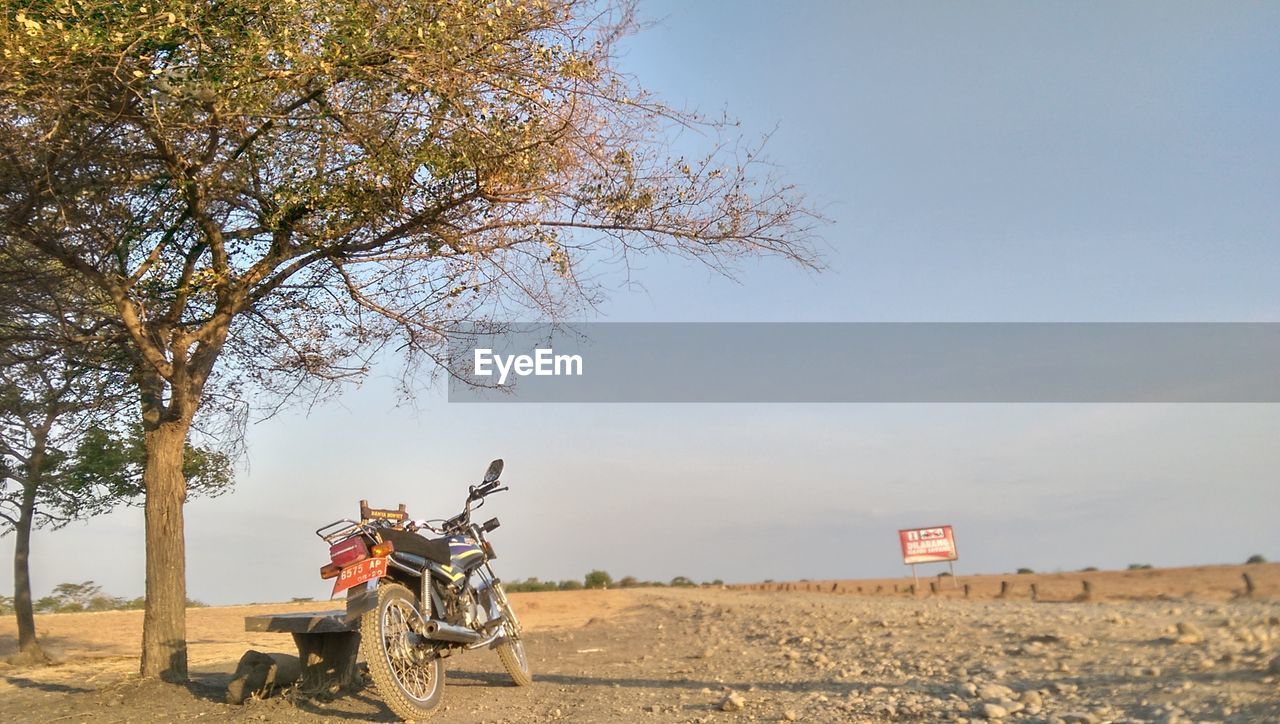 BICYCLE PARKED ON ROAD AGAINST SKY