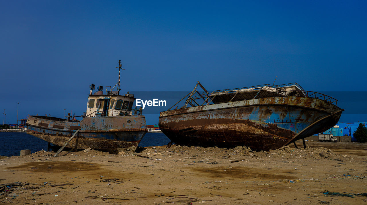 VIEW OF ABANDONED SHIP ON BEACH