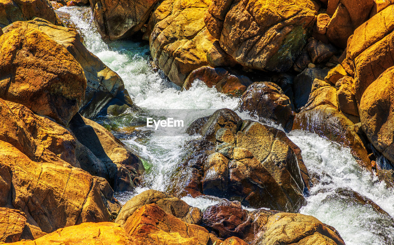 autumn, rock, water, beauty in nature, stream, nature, no people, motion, scenics - nature, day, river, land, high angle view, leaf, rapid, outdoors, waterfall, wilderness, flowing water, body of water, water feature, rock formation, geology, tranquility, non-urban scene, sunlight, flowing