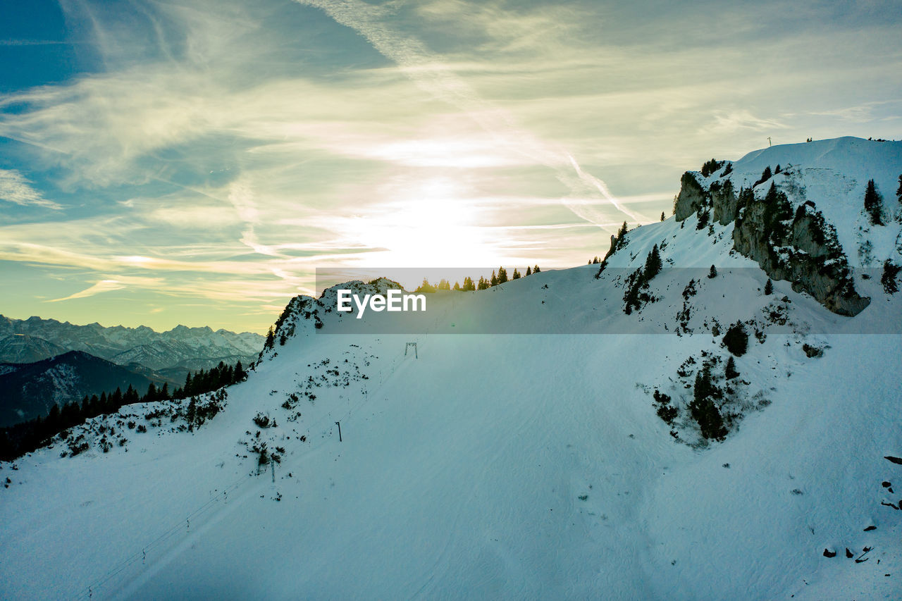 Scenic view of snow covered mountains against sky during sunset