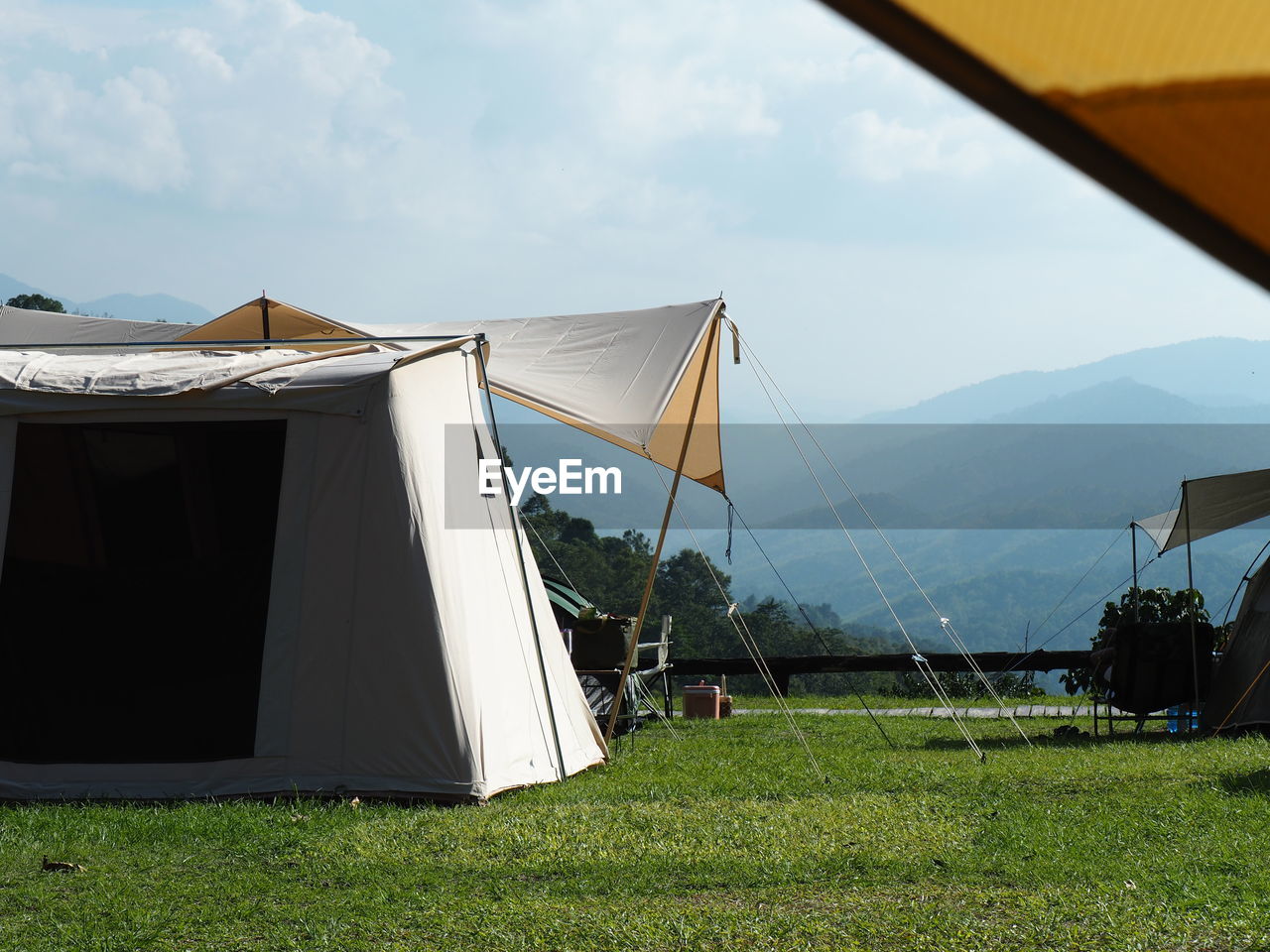 tent, grass, nature, sky, camping, environment, plant, architecture, no people, built structure, land, day, mountain, landscape, outdoors, building exterior, field, tranquility, cloud, beauty in nature, sunlight, travel, vacation, building, scenics - nature, trip, house