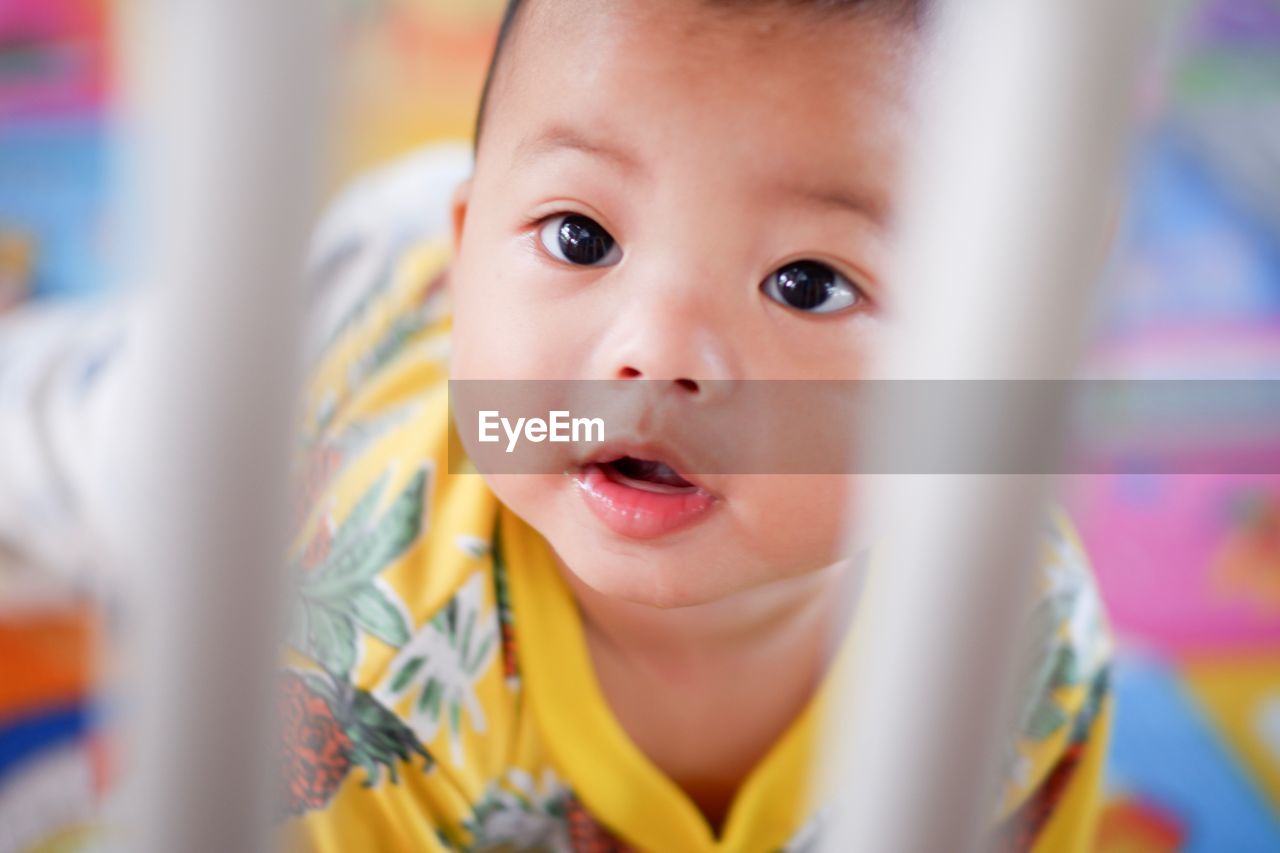 High angle portrait of cute baby girl kneeling in crib