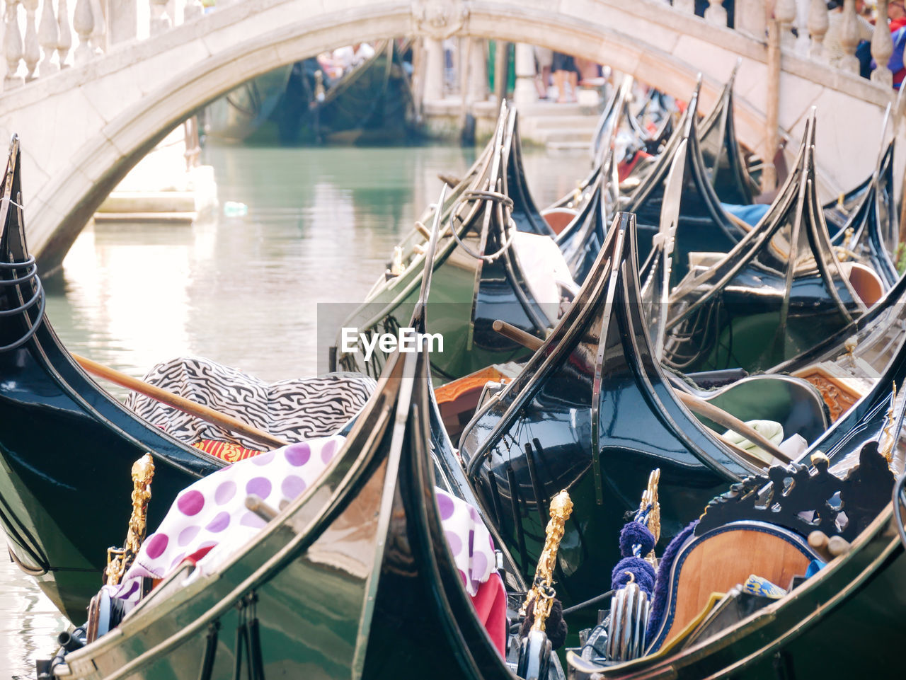 Group of traditional gondolas moored on narrow canal in venice