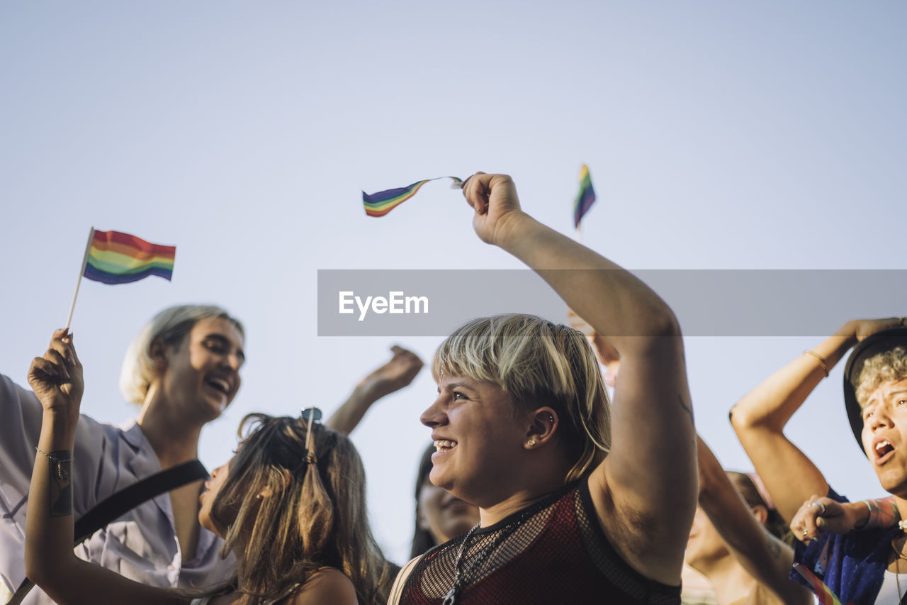 Happy non-binary person with friends enjoying in lgbtqia rights parade