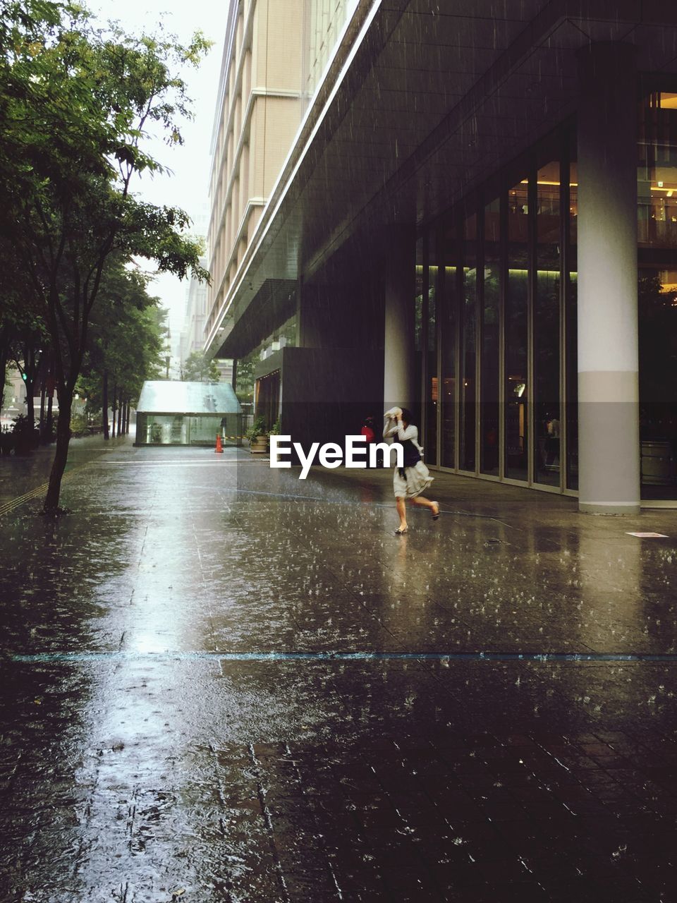 Woman running out on sidewalk on rainy day