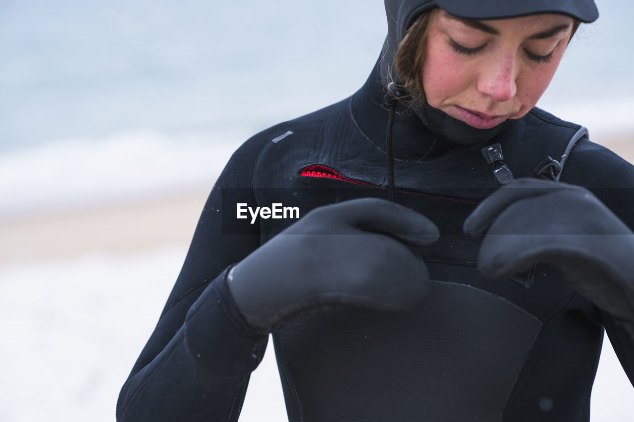 Young woman preparing to go winter surfing in snow