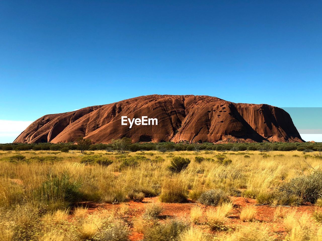 Rock formations on landscape against clear blue sky