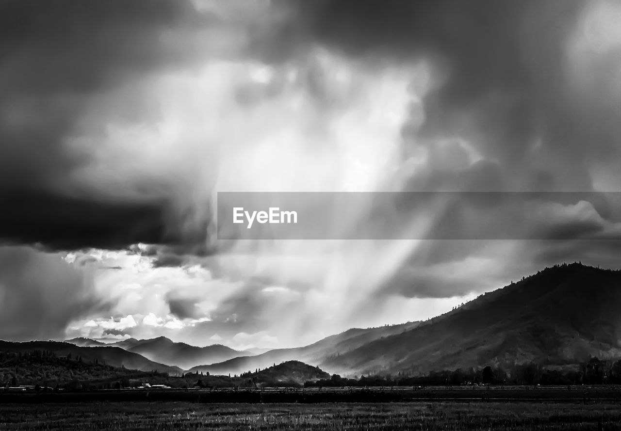 Scenic view of mountains against storm clouds