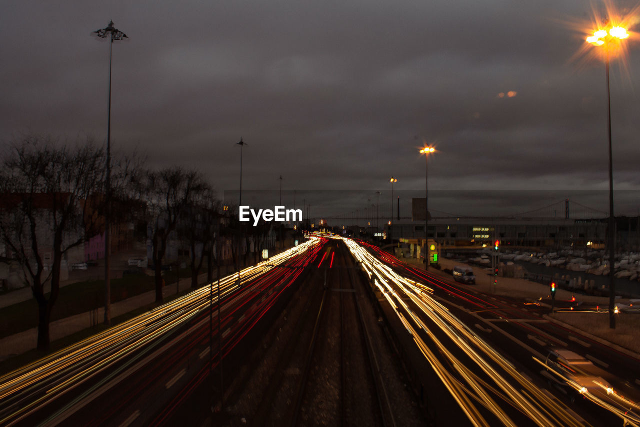 LIGHT TRAILS ON STREET AGAINST SKY