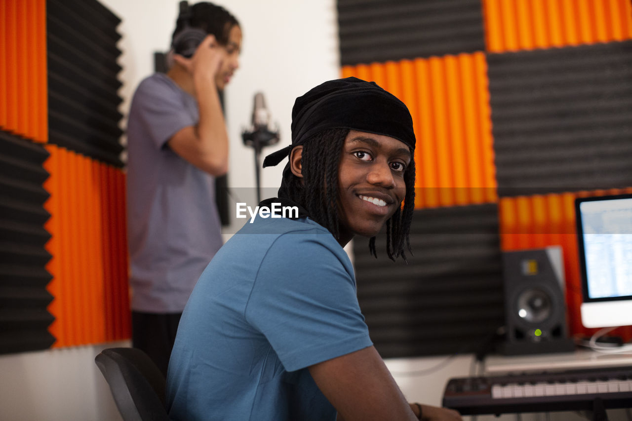 Smiling music composer sitting in recording studio