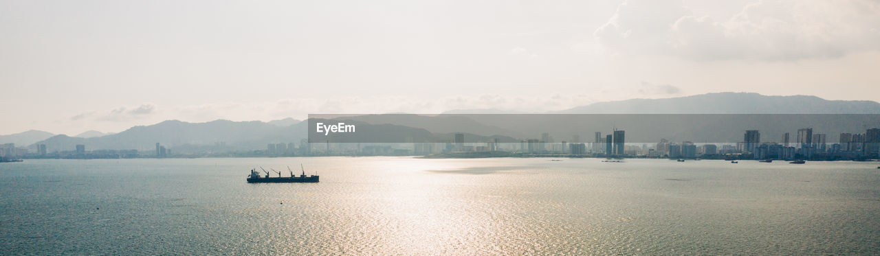 SCENIC VIEW OF SEA AND CITY AGAINST SKY