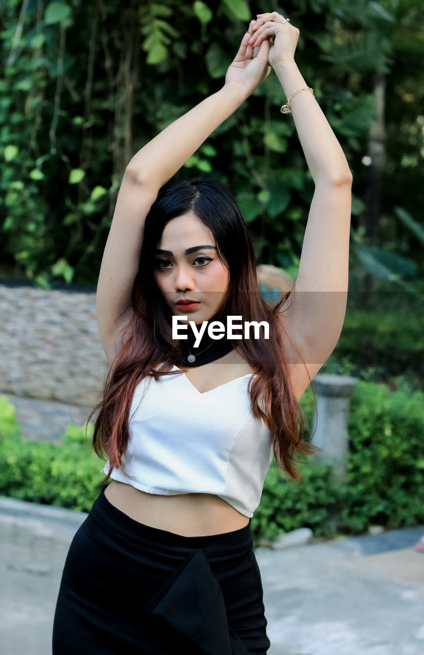 Portrait of beautiful young woman standing in park