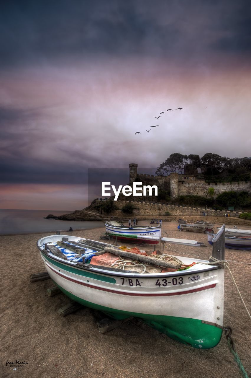 BOATS MOORED ON SEA AGAINST SKY DURING SUNSET