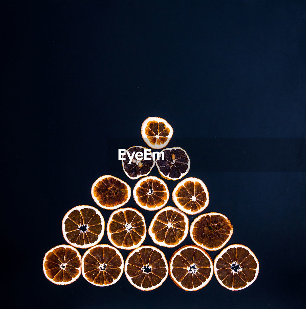 Christmas tree made from dried orange slices on black background