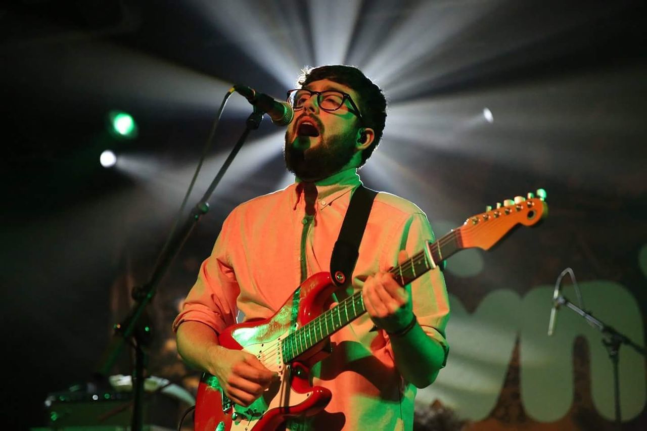 PERSON PLAYING GUITAR ON LEAF