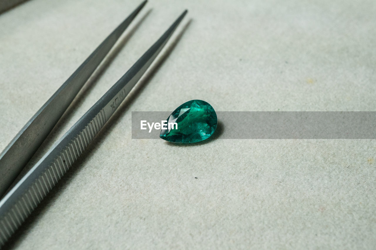 HIGH ANGLE VIEW OF GREEN CONTAINER ON GLASS TABLE