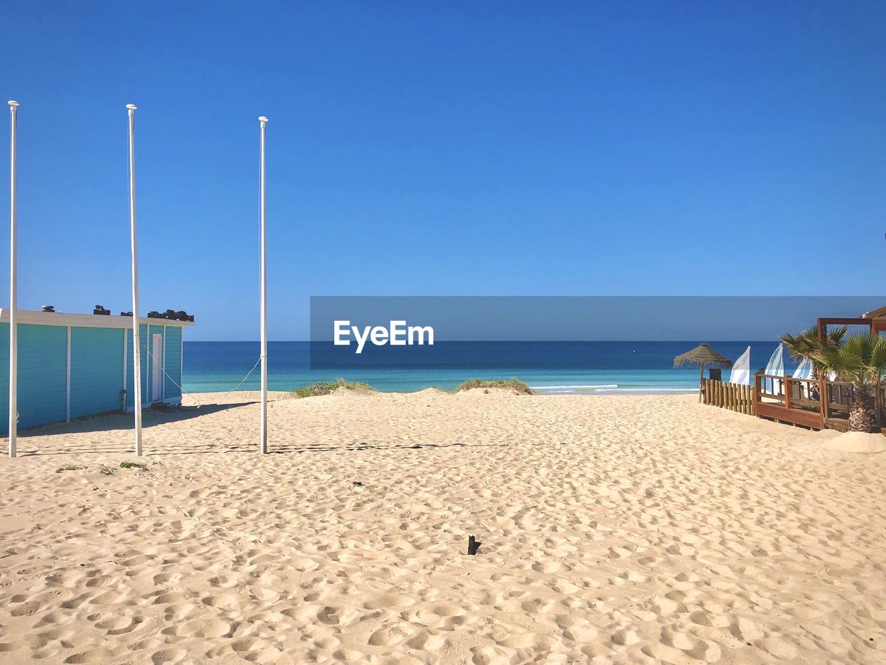 Scenic view of beach against clear blue sky