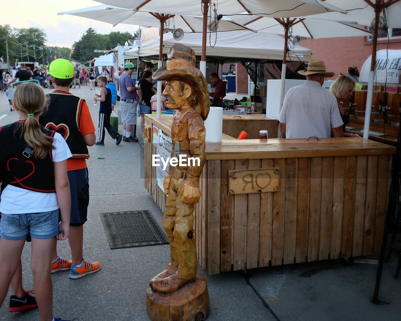 People standing by wooden statue in market