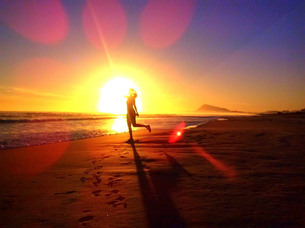 Side view of silhouette woman standing on one leg at beach