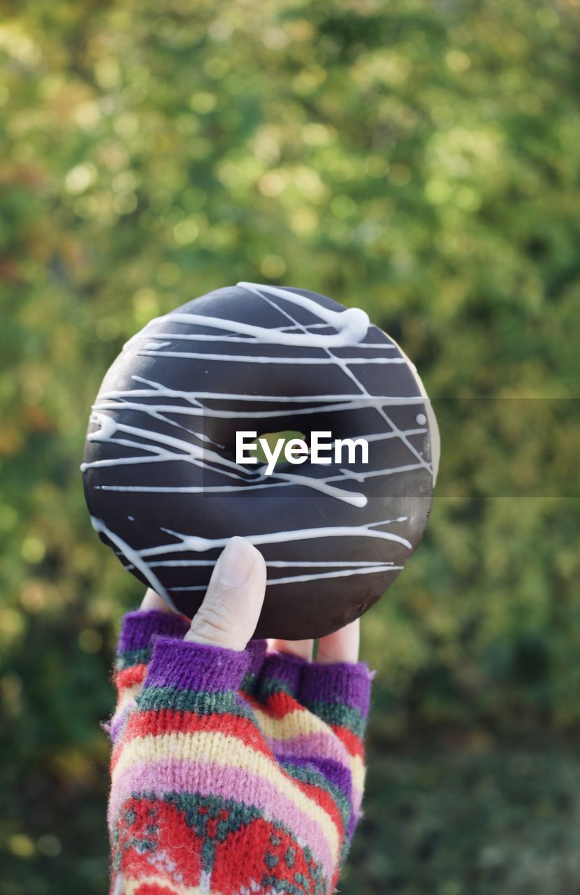 CLOSE-UP OF PERSON HOLDING HAT