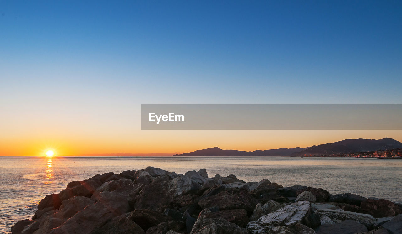 Scenic view of sea against clear sky during sunset