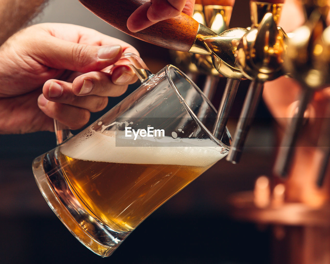 cropped hand of person holding beer glass