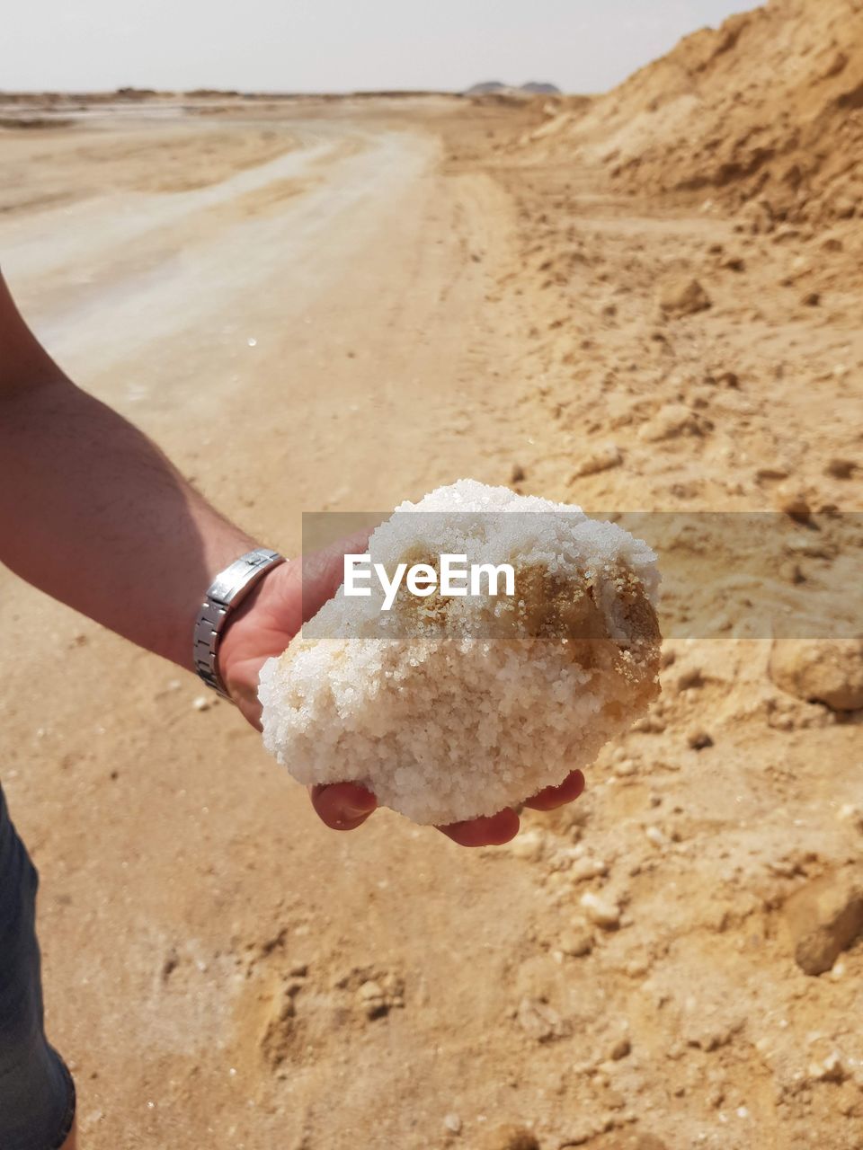 MIDSECTION OF PERSON HOLDING SAND ON BEACH