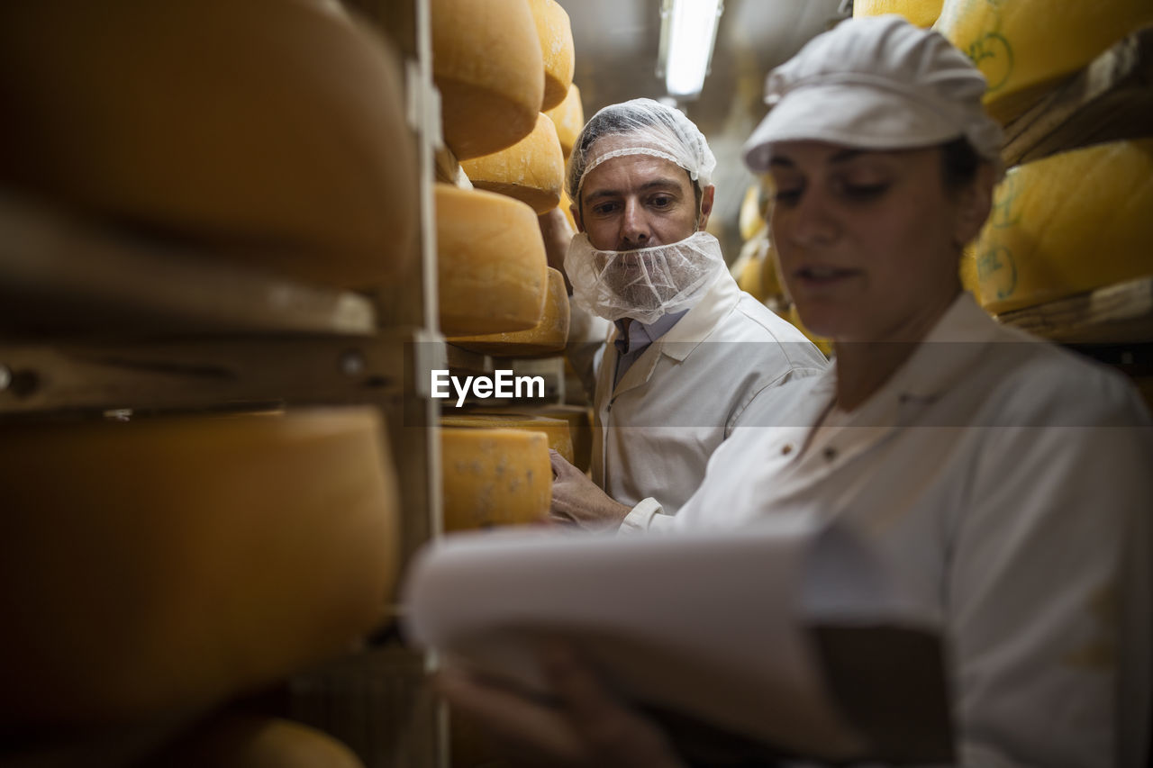 Cheese factory worker controlling maturation of cheese
