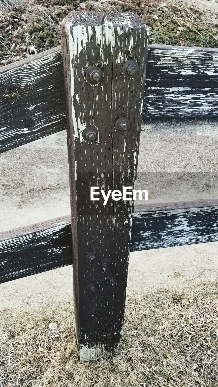 CLOSE-UP OF WOODEN POST IN WATER